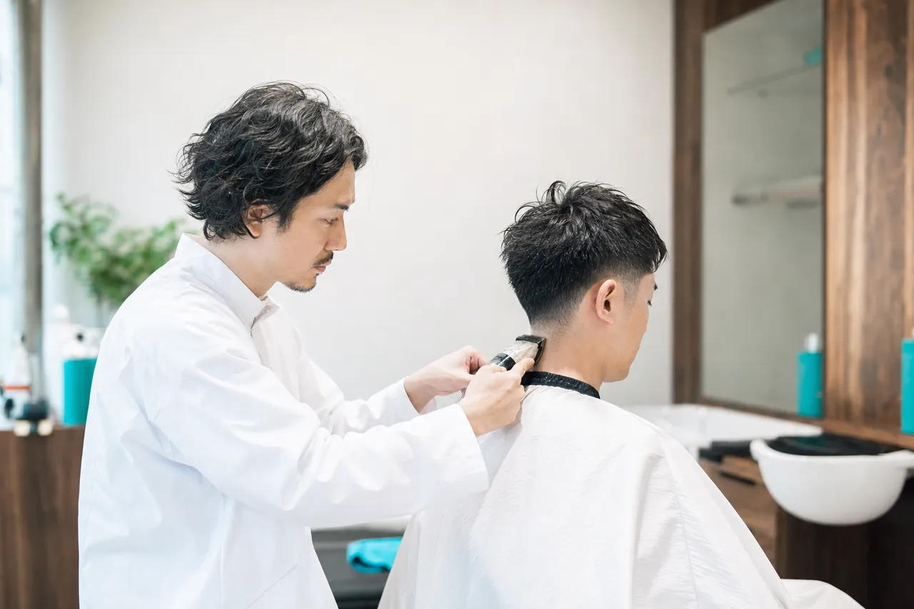 理容室で男性客の襟足を整える理容師