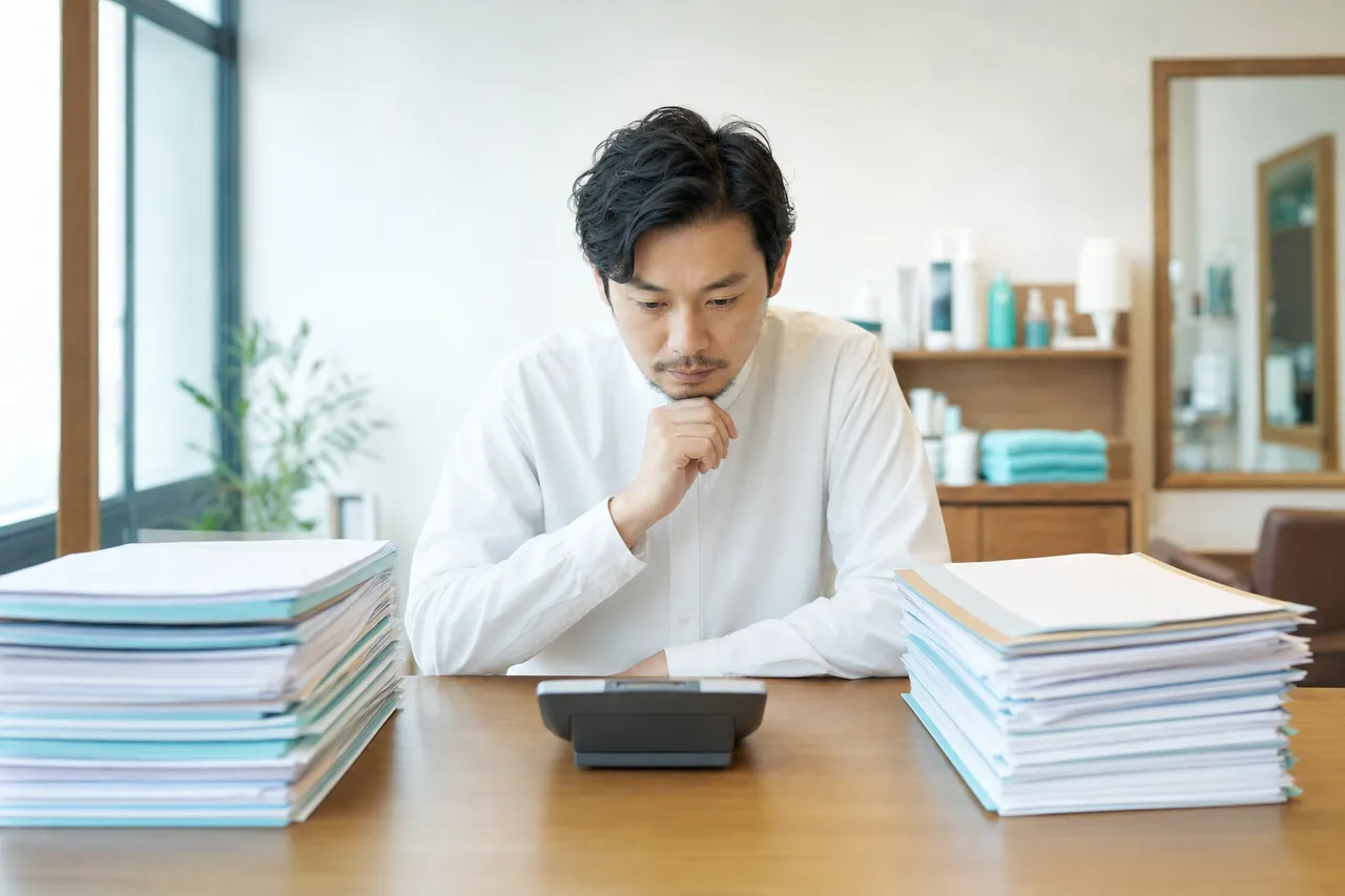 書類を見比べて費用を比較するデスク